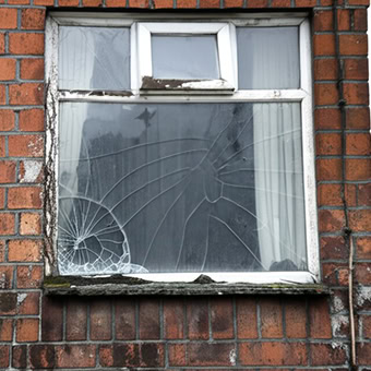 Cracked window on a brick wall building.