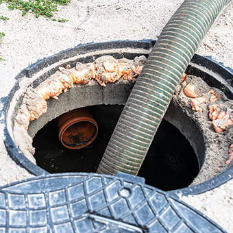 Septic tank cleaning with hose insertion