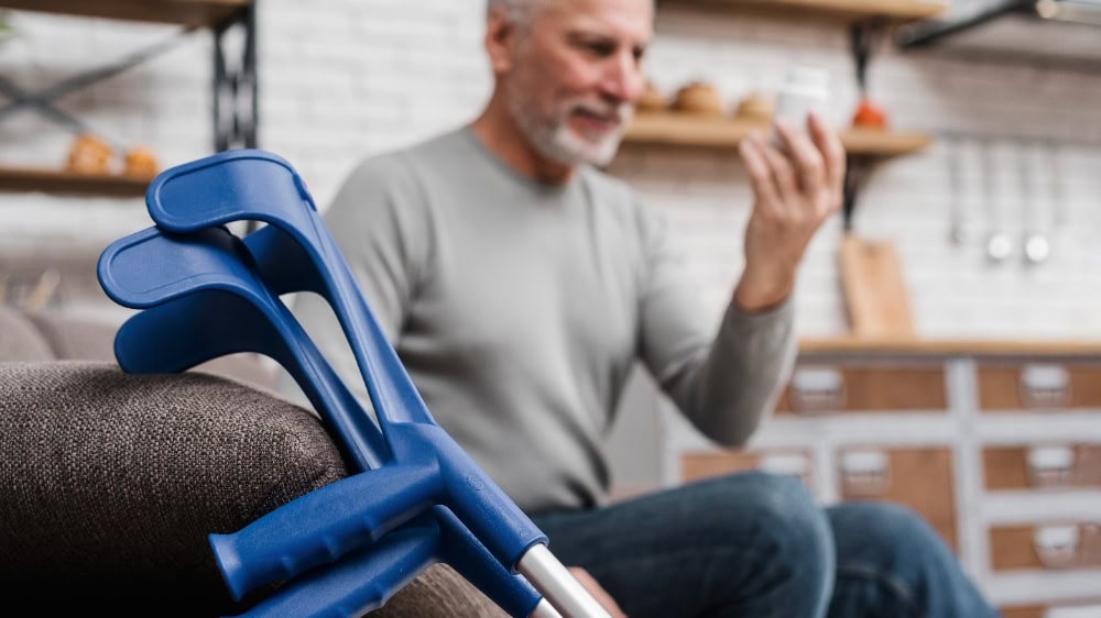 Blue crutches near man holding phone